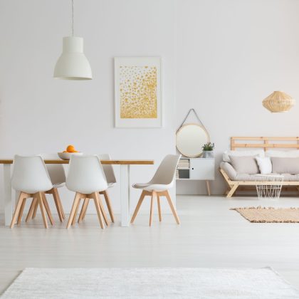 Prosta jadalnia i minimalistyczny salon w białym lofcie lagom