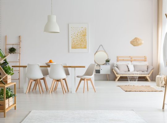 Prosta jadalnia i minimalistyczny salon w białym lofcie lagom