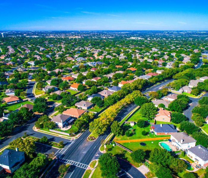 Setki domów wzdłuż zakrzywionych nowoczesnych dróg nowego przedmieścia na północ od Austin w Round Rock, Teksas, USA widok z lotu ptaka nad przedmieściem suburbia społeczność sąsiedzka