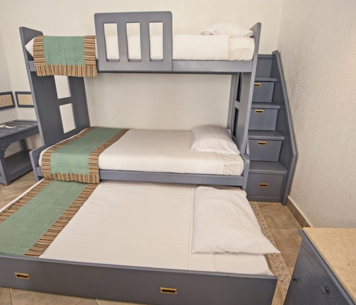 Oszczędzające miejsce łóżka piętrowe w rodzinnej sypialni z pomysłem na przechowywanie ze schodkami