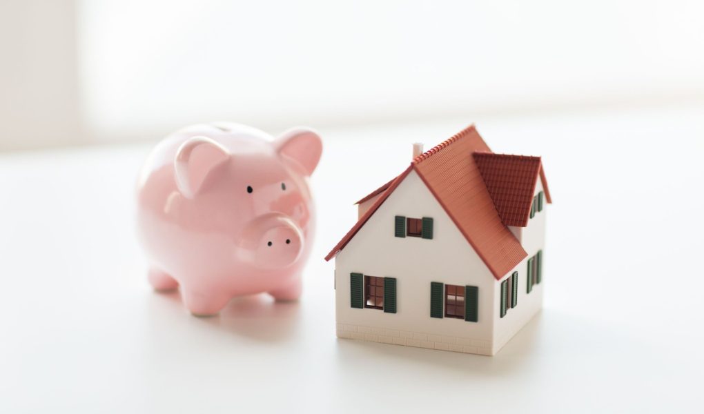 Koncepcja budynku, kredytu hipotecznego, inwestycji, nieruchomości i nieruchomości - zbliżenie modelu domu lub domu i skarbonki