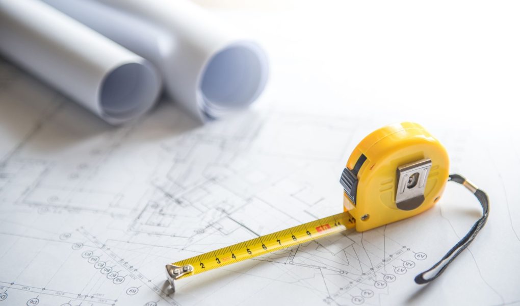 rysunek architektoniczny plan projektu domu rolki i żółta taśma miernicza (taśma miernicza) na stole roboczym koncepcje branży budowlanej