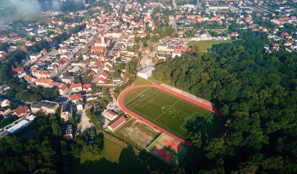 Widok z lotu ptaka na małe europejskie miasto z stadionem i boiskiem sportowym