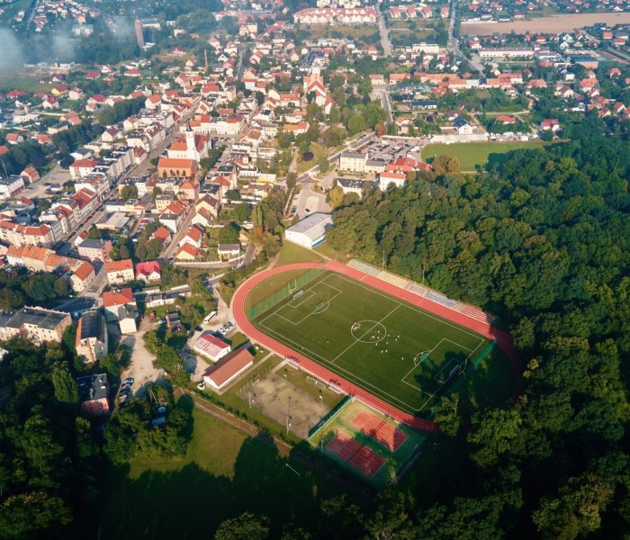 Widok z lotu ptaka na małe europejskie miasto z stadionem i boiskiem sportowym